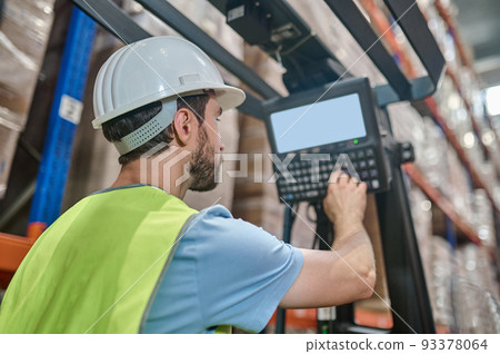Experienced warehouse employee operating the electric lift truck 93378064