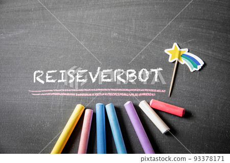 Travel ban. German word Reiseverbot. Text on a dark chalk board 93378171