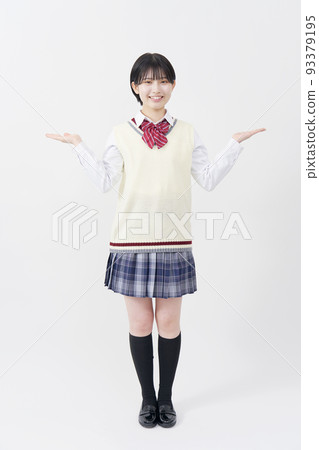 一個高中女生，她用手掌在白色背景上指向兩邊。 93379195