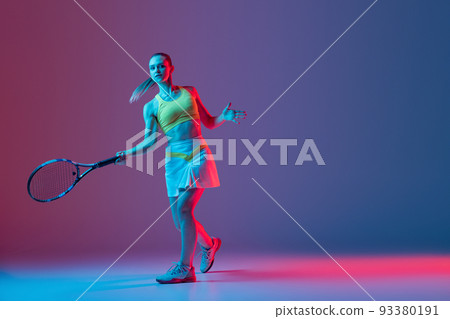 Full length portrait of young woman playing tennis isolated on dark background in neon. Healthy lifestyle, fitness, sport, exercise concept. 93380191