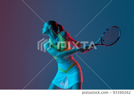 Young woman, professional tennis player training isolated on blue background in neon. 93380262