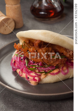 bao bun with breaded chicken, pickled onion and sauce bao bun with breaded chicken, pickled onion and sauce 93382399