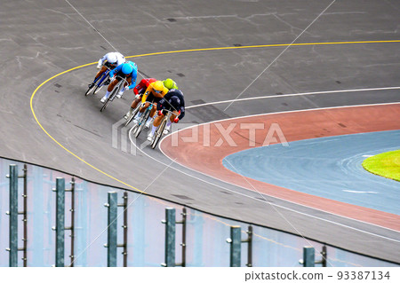 Bicycle racers running around the final corner and rushing over the bank and rushing to the goal 93387134
