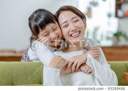Elementary school girl hugging mom from behind 93389486
