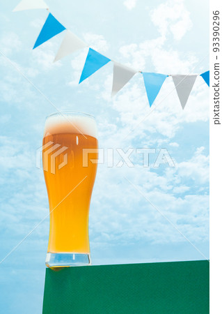 Glass of cold frothy light beer over summer blue sky background. Vacation, happiness, summer vibes and ad concept. Retro style Glass of cold frothy light beer over summer blue sky background. Vacation, happiness, summer vibes and ad concept. Retro style 93390296