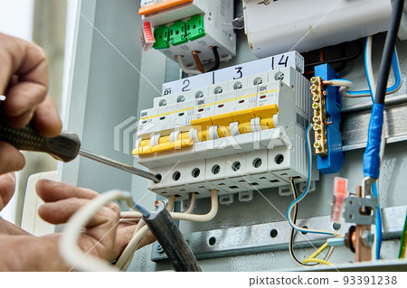 Connecting wires to circuit breaker fuse box in consumer unit of distribution panel. 93391238