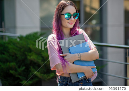 Portrait beautiful female writer dressed in casual outfit holding modern laptop in hand. Portrait beautiful female writer dressed in casual outfit holding modern laptop in hand. 93391270