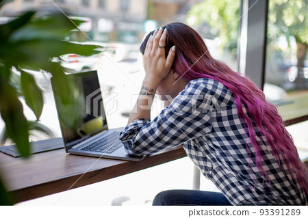 Woman typing on notebook with blank screen, sitting at wooden table Woman typing on notebook with blank screen, sitting at wooden table 93391289