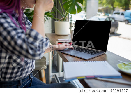 Woman typing on notebook with blank screen with copy space for your text or advertising content, sitting at wooden table Woman typing on notebook with blank screen with copy space for your text or advertising content, sitting at wooden table 93391307