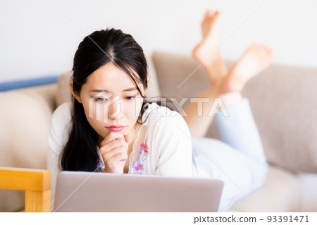 在家沙發上放鬆的年輕女人 在家沙發上放鬆的年輕女人 93391471