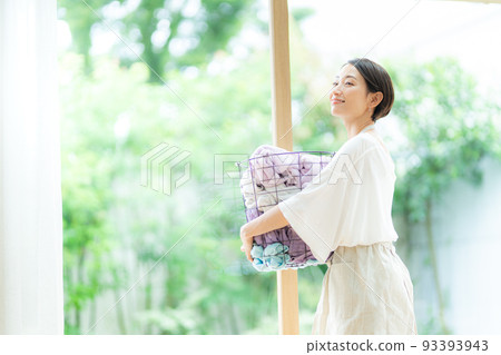 Woman with laundry basket 93393943
