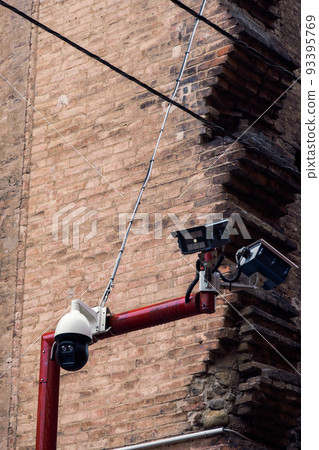 CCTV security surveillance cameras above a street. 93395769