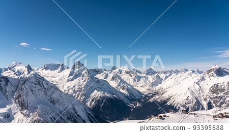 Panoramic view of winter snowy mountains in Caucasus region in Russia with blue sky 93395888