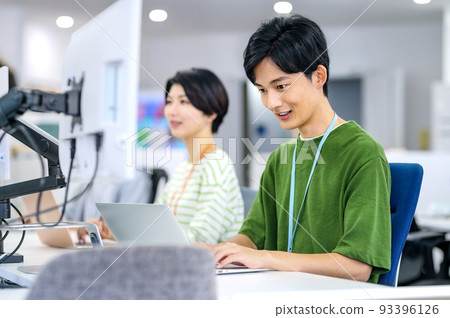 Young engineer in plain clothes working in the office Young engineer in plain clothes working in the office 93396126
