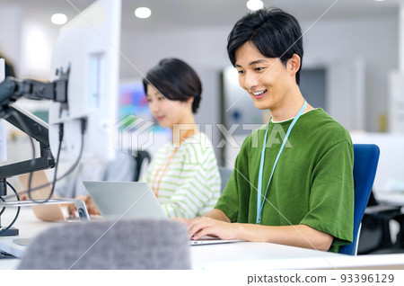 Young engineer in plain clothes working in the office Young engineer in plain clothes working in the office 93396129
