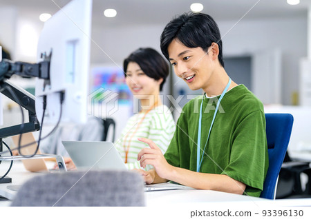 Young engineer in plain clothes working in the office Young engineer in plain clothes working in the office 93396130