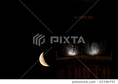 Beautiful quarter moon over Riga old town behind Domes cathedral clock. Night sky with amazing moon. Beautiful quarter moon over Riga old town behind Domes cathedral clock. Night sky with amazing moon. 93396745