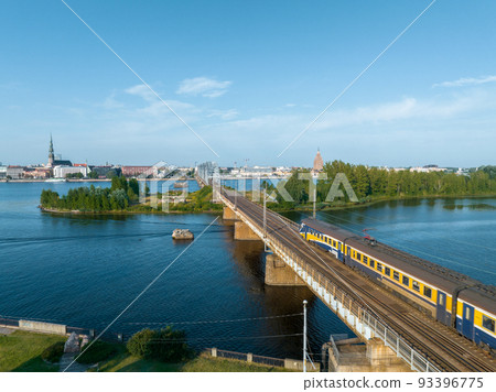 Train crossing river Daugava in Riga, Latvia. Beautiful aerial view of Riga. Train crossing river Daugava in Riga, Latvia. Beautiful aerial view of Riga. 93396775