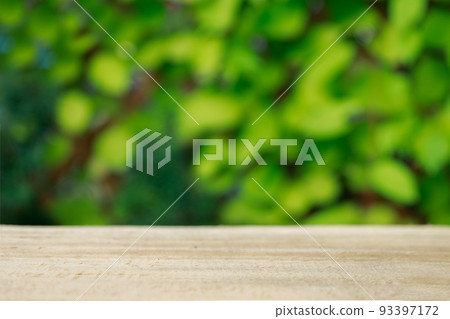 Mock-up Wood table top texture on blur leaf tree garden background. For create product display 93397172