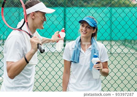 Young couple in sportswear flirting after game of tennis 93397287
