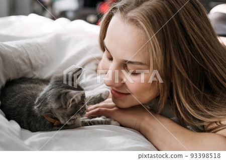 Cat Adoption, Adopt kitten from rescues and shelters. Rehome a Cat. Portrait of woman playing with outbred homeless adopted grey kitten Cat Adoption, Adopt kitten from rescues and shelters. Rehome a Cat. Portrait of woman playing with outbred homeless adopted grey kitten 93398518