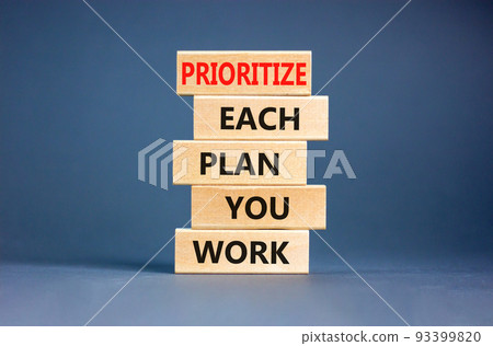 Prioritize each plan you work symbol. Concept words Prioritize each plan you work on wooden blocks on beautiful grey table grey background. Business prioritize each plan you work concept. Copy space 93399820