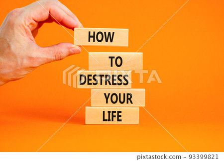 Destress your life symbol. Concept words How to destress your life on wooden blocks. Doctor hand. Beautiful orange background. Psychological business and destress your life concept. Copy space. 93399821