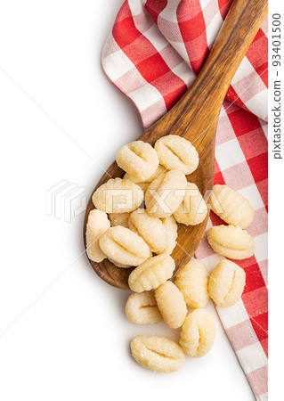 Uncooked potato gnocchi in wooden spoon isolated on white background. 93401500