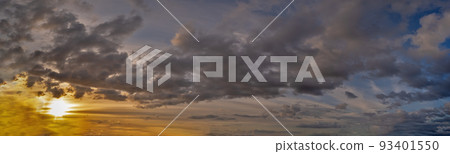 Panorama of cumulus fluffy white and dark gray storm clouds against sunset. 93401550