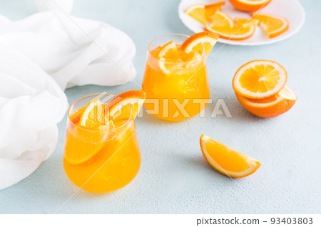 Hard seltzer cocktail with orange in glasses on the table. Homemade drink. Hard seltzer cocktail with orange in glasses on the table. Homemade drink. 93403803