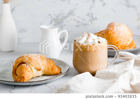 Fresh croissant on a plate and a big cup of coffee on the table. Homemade breakfast lifestyle 93403835