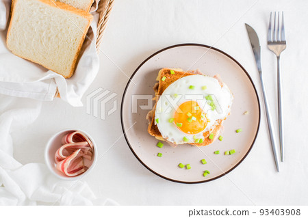 Homemade sandwich - croque madame on a plate on a light table. Top view 93403908