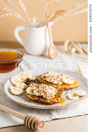 Ready to eat sandwiches with honey, banana and chocolate on a plate on the table. Homemade vegetarian snack. Vertical view Ready to eat sandwiches with honey, banana and chocolate on a plate on the table. Homemade vegetarian snack. Vertical view 93403974