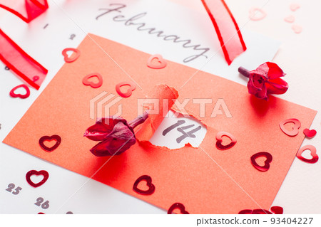 Valentine's Day. The date February 14 is highlighted with a hole in red cardboard, dried flowers and a ribbon on a pink background Valentine's Day. The date February 14 is highlighted with a hole in red cardboard, dried flowers and a ribbon on a pink background 93404227