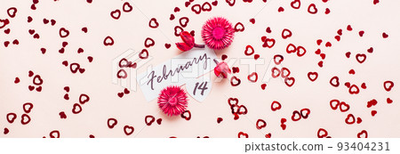 Valentine's Day. Date of February 14 and dry flowers on a pink background strewn with hearts. Top view. Web banner 93404231