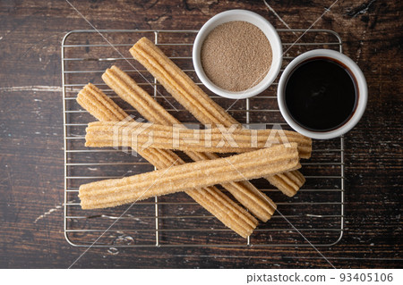 churros with chocolate sauce and cinnamon powder 93405106