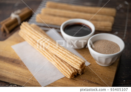 churros with chocolate sauce and cinnamon powder 93405107
