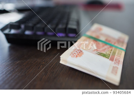 Russian money above the black computer keyboard. Remote job and freelance in Russia. Banknote of 5000 rubles. Russian money above the black computer keyboard. Remote job and freelance in Russia. Banknote of 5000 rubles. 93405684