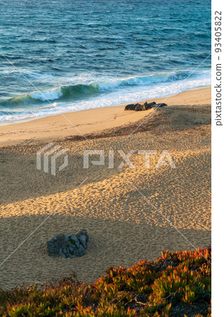 Deserted sandy beach of the atlantic ocean in the rays of the setting sun 93405822