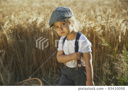 Adorable sad street child in a field Adorable sad street child in a field 93410098