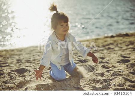 Charming child walking on the beach at sunset Charming child walking on the beach at sunset 93410104
