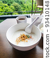 Minced Pork Congee with Soft Boiled Egg in bowl on wood table. 93410148