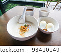Minced Pork Congee with Soft Boiled Egg in bowl on wood table. 93410149