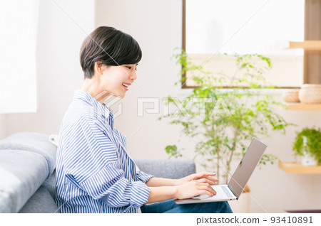 A young woman using a laptop in the living room A young woman using a laptop in the living room 93410891