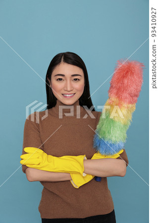 Glad smiling and optimistic asian houseworker cross hands from chores holding colorful dust brush in yellow glove, Housewife worker, Cleaning home concept, Feeling joyful and positive at work 93410927
