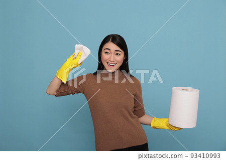 Excited smiling and joyful asian housekeeper at work with tissue paper holding in the yellow glove, Cleaning home concept, Happy laughing housewife with positive state of mind 93410993