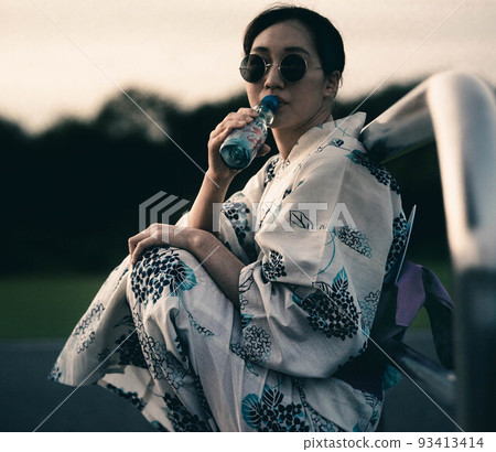 一個穿著浴衣和太陽鏡喝著 ramune 的女人 93413414