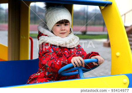 Little child girl playing on playground outdoors in car Little child girl playing on playground outdoors in car 93414977