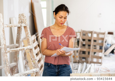 Woman construction manager checking project documentation Woman construction manager checking project documentation 93415644