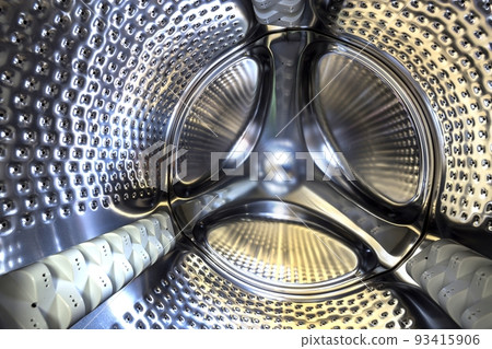 Close-up detail, stainless drum of modern washing machine interior. Abstract silver shiny surface design. 93415906
